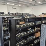 Photo de la ferme de SIM découverte en Lettonie lors de l’opération SIMcartel, illustrant les risques croissants de cyberfraude à l’échelle internationale.